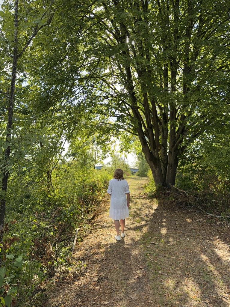 Claudia Trompeter auf einem Weg unter Bäumen